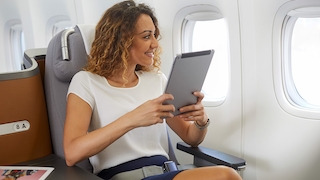 Frau nutzt Lufthansa Mobile am Tablet