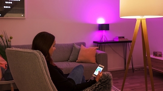 Tint-Lampe und Smartphone-Nutzerin im Wohnzimmer