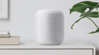 Apple HomePod in weiß steht auf einem Schrank.