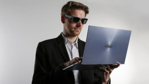 Redakteur mit Sonnenbrille und Jacket hält das Asus ZenBook 14 und schaut auf das Display. © COMPUTER BILD