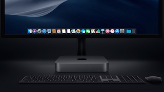 Mac mini steht in dunkler Umgebung vor einem Monitor