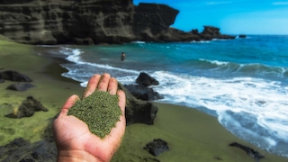 Grüner Sand in einer Hand