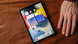 Das iPad mini liegt neben einer Hand.