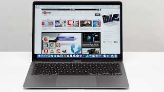 MacBook Air steht auf einem Tisch vor grauem Hintergrund.
