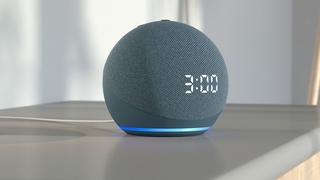 Amazon Echo Dot mit Uhr steht auf einem Schrank.