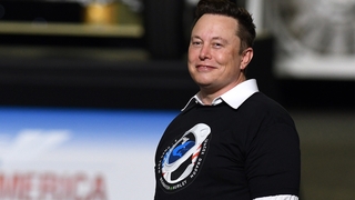 Elon Musk steht auf einer Bühne.