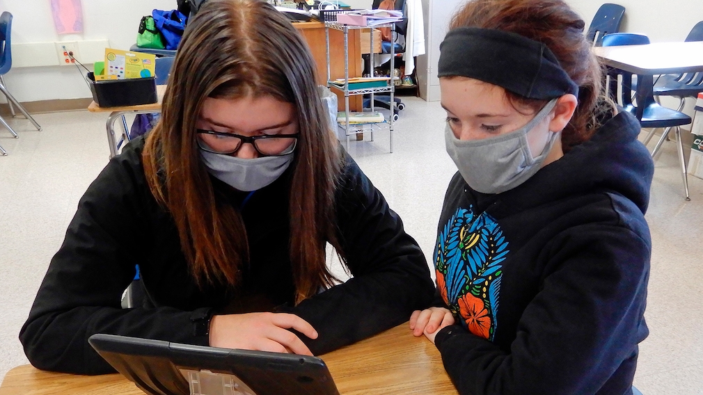 Zwei Schülerinnen lernen mit einem Tablet 