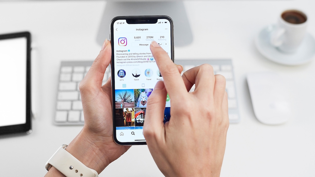 Handy-Nutzer tippt auf Bildschirm mit Instagram-App