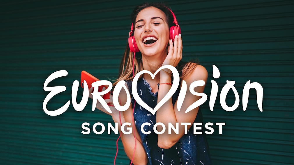Lachende Frau mit Kopfhörern und Handy hinter Eurovision-Schriftzug