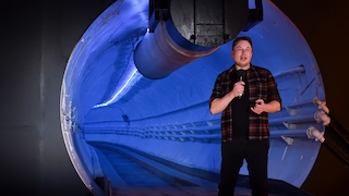 Elon Musk vor einer blau beleuchteten Tunnelröhre