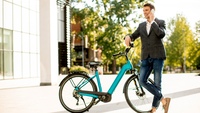 Man neben E-Bike telefoniert