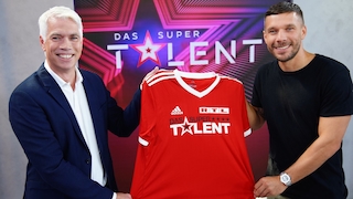 Henning Tewes und Lukas Podolski mit Fußball-Trikot vor dem Supertalent-Logo