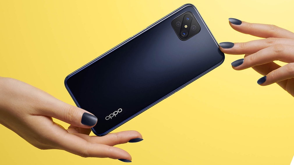 Finger mit schwarz lackierten Nägeln balancieren ein schwarzes Oppo-Handy vor orangem Hintergrund