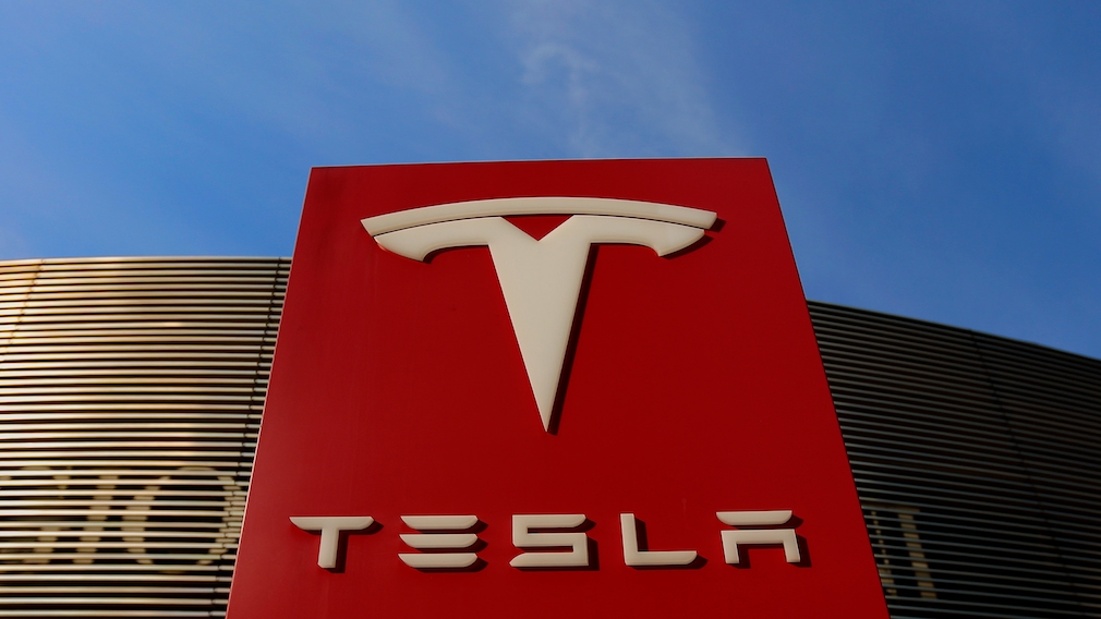 Säule mit Tesla-Logo vor blauem Himmel