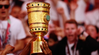 Der DFB-Pokal vor jubelnden Menschen Sportwetten