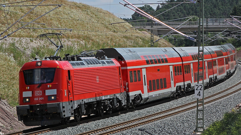 Ein Regionalzug der Deutschen Bahn fährt auf Schienen.