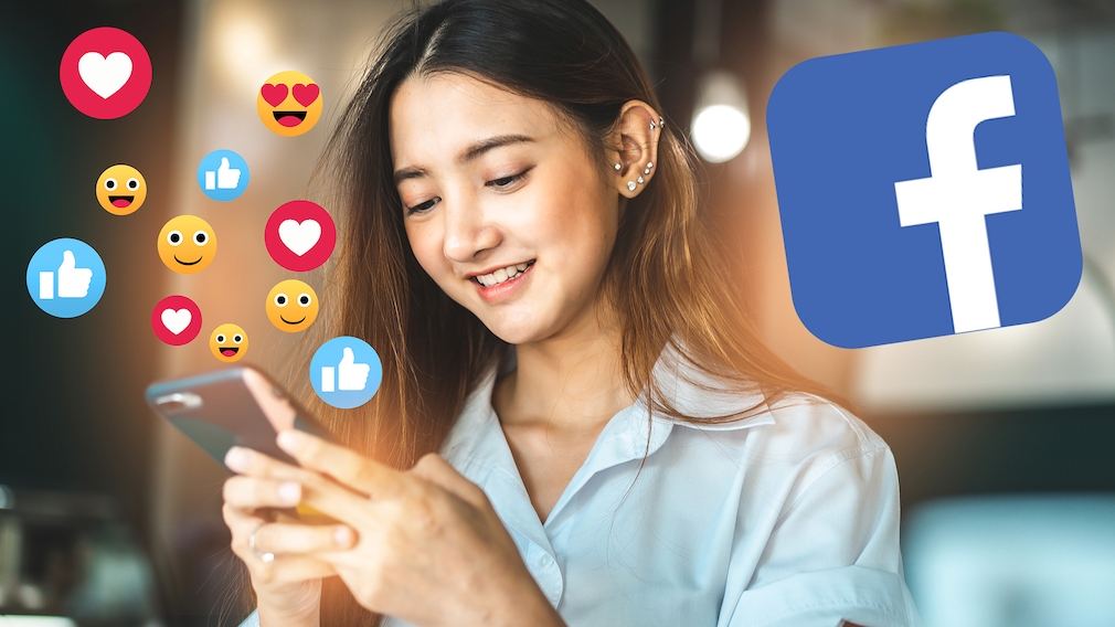 Mädchen am Smartphone mit Facebook Logo und Emoticons