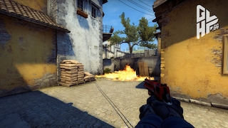 Ein Spieler richtet seine Pistole auf Gegner hinter einer Feuerwand.