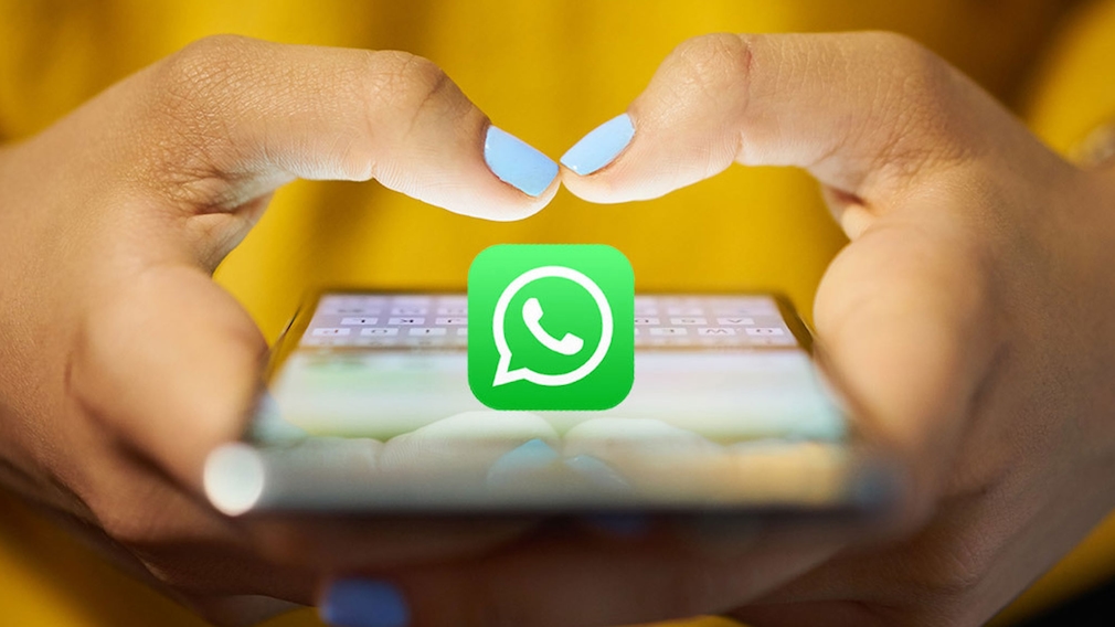 Smartphone mit WhatsApp-Icon in den Händen einer Frau