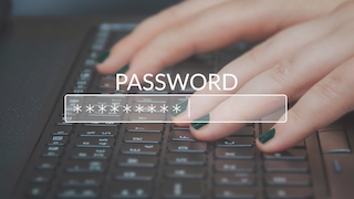 Passwort Eingabefeld mit Hand und Tastatur im Hintergrund