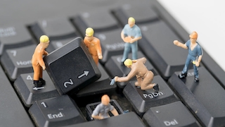 Laptop Tastatur und Miniatur-Figuren 