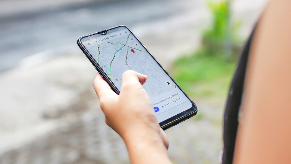Frau benutzt Google Maps auf ihrem Handy