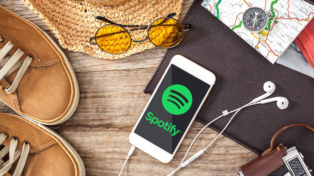 Smartphone mit Spotify Logo und weiteres Reisegepäck 