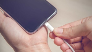 Person schlie�t iPhone an das Ladekabel an © iStock.com/oatawa