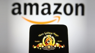 MGM-Löwe auf Handy vor Amazon-Logo im Hintergrund