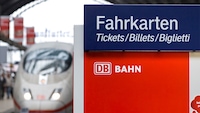 Zug der Deutschen Bahn neben Fahrkarten-Schild