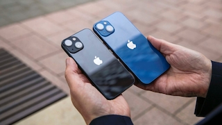 Zwei Hände halten das iPhone 13 mini und das iPhone 13.