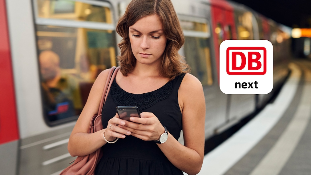 Frau mit Handy vor Zug neben App-Logo der Deutschen Bahn