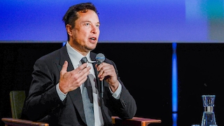 Elon Musk spricht in ein Mikrofon