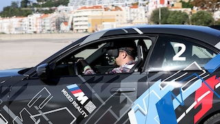 Fahrer mit VR-Brille am Steuer eines BMW