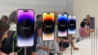 Vier auf Stangen montierte iPhones mit eingeschaltetem Display.