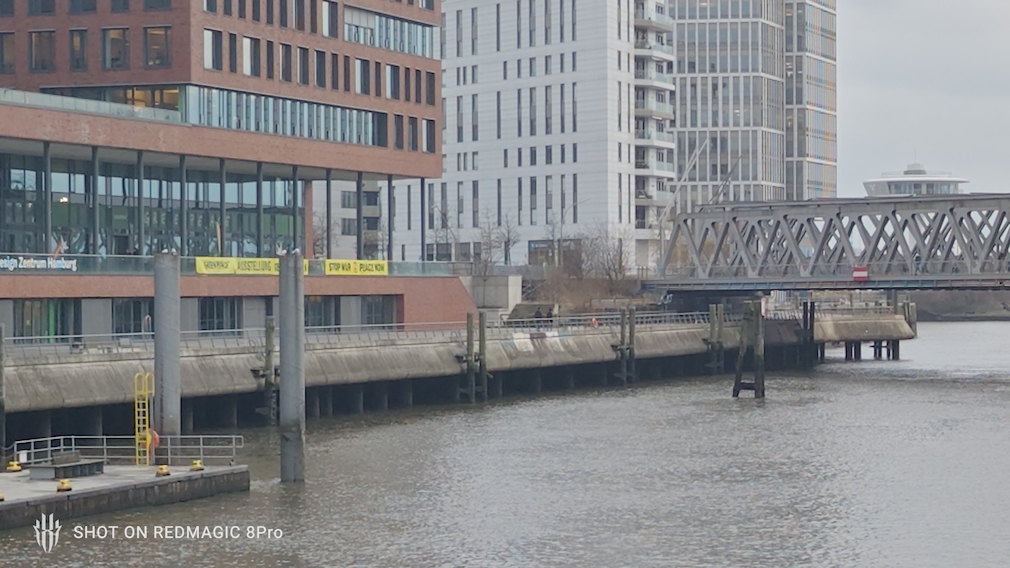 Blick auf eine Brücke, einen Fluss und das Greenpeace Gebäude