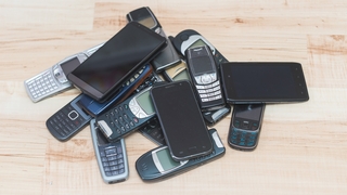 Viele alte Handys auf einem Holzboden liegend