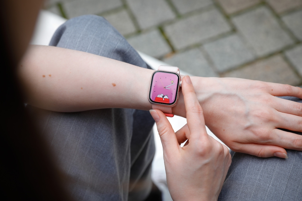 Apple Watch 9 mit Snoopy Watchface am Handgelenk einer Frau