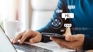 Computer und Smartphone mit Chatbot-Emoji