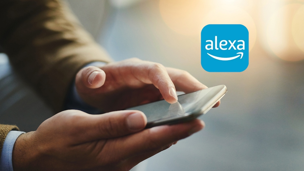 Mann hält Handy, Alexa-App-Logo
