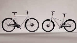 Zwei E-Bikes vor grauem Hintergrund.
