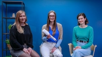 Drei Frauen vor einer blauen Wand mit dem ghd Duet Style Hot Air Styler