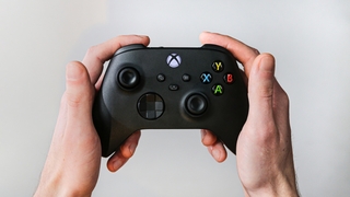 Zwei Hände halten einen Xbox-Controller