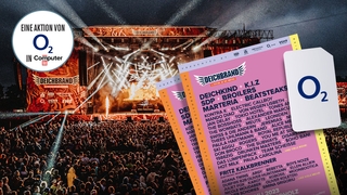 Eine Bühne des Deichbrand Festivals im Hintergrund, im Vordergrund Festivaltickets und eine O2-SIM-Karte