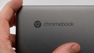 Ein Hand berührt den Deckel eines Chromebooks.