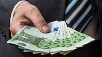 Männerhand hält mehrere Hundert-Euro-Scheine