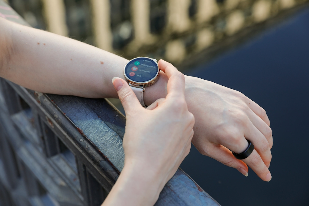 Menü der Huawei Watch GT 4, während der Arm der Frau auf einem Geländer liegt. 