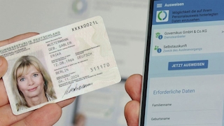 Eine Person hält einen Personalausweis neben ein Smartphone.