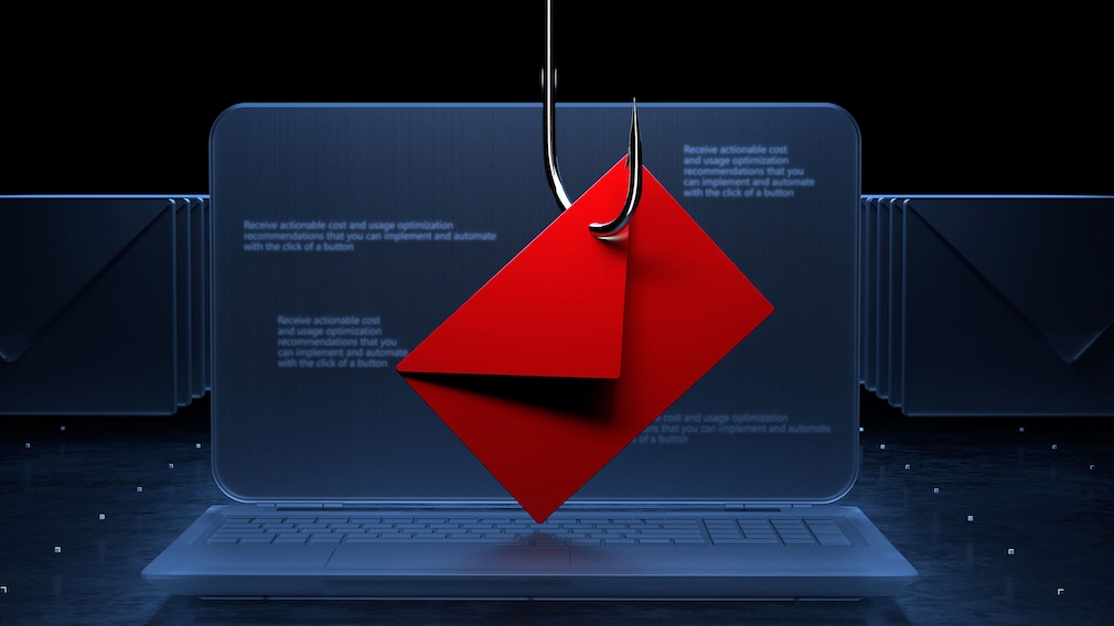 Ein Briefumschlag hängt vor einem Laptop an einem Haken.
