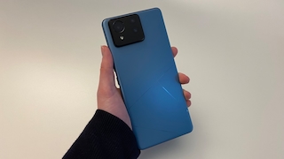 Asus Zenfone 11 Ultra in Blau gehalten von einer Hand vor einem weißen Hintergrund. Die Rückseite des Smartphones ist zu sehen.